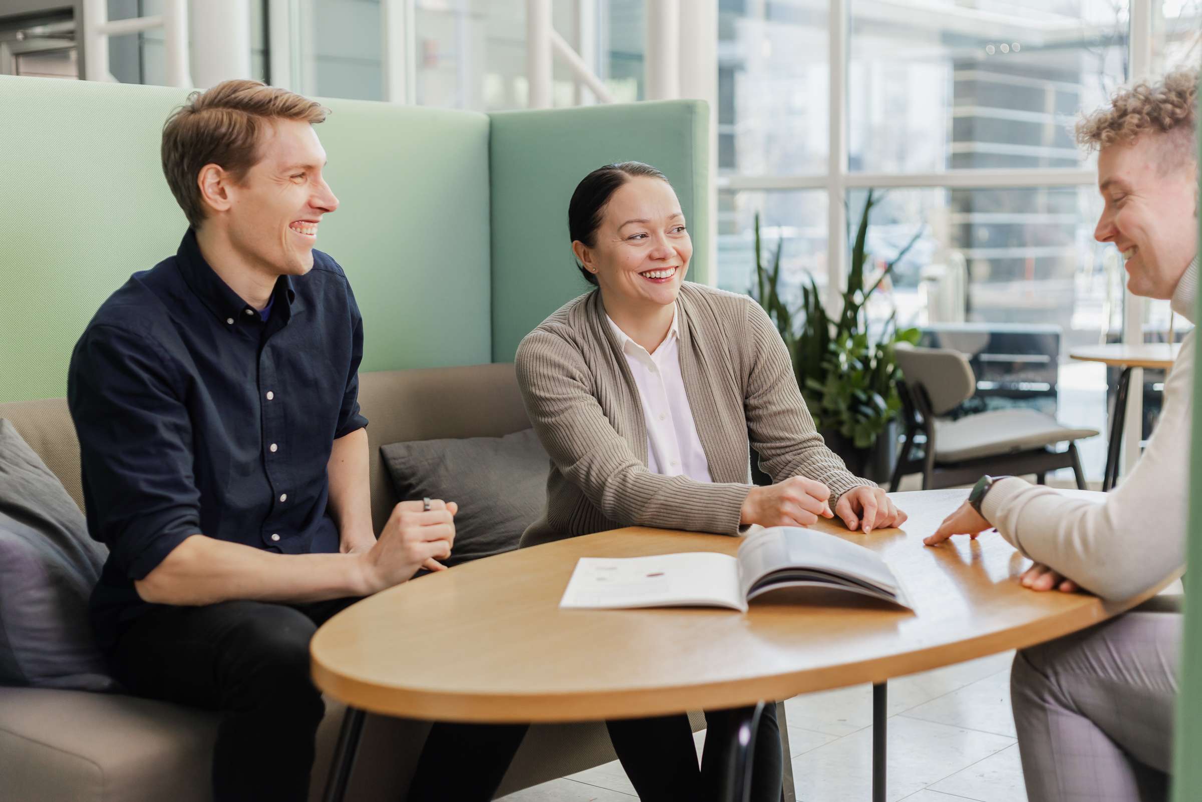 Vieser staff members seated around a table in a modern office, engaged in a collaborative discussion.